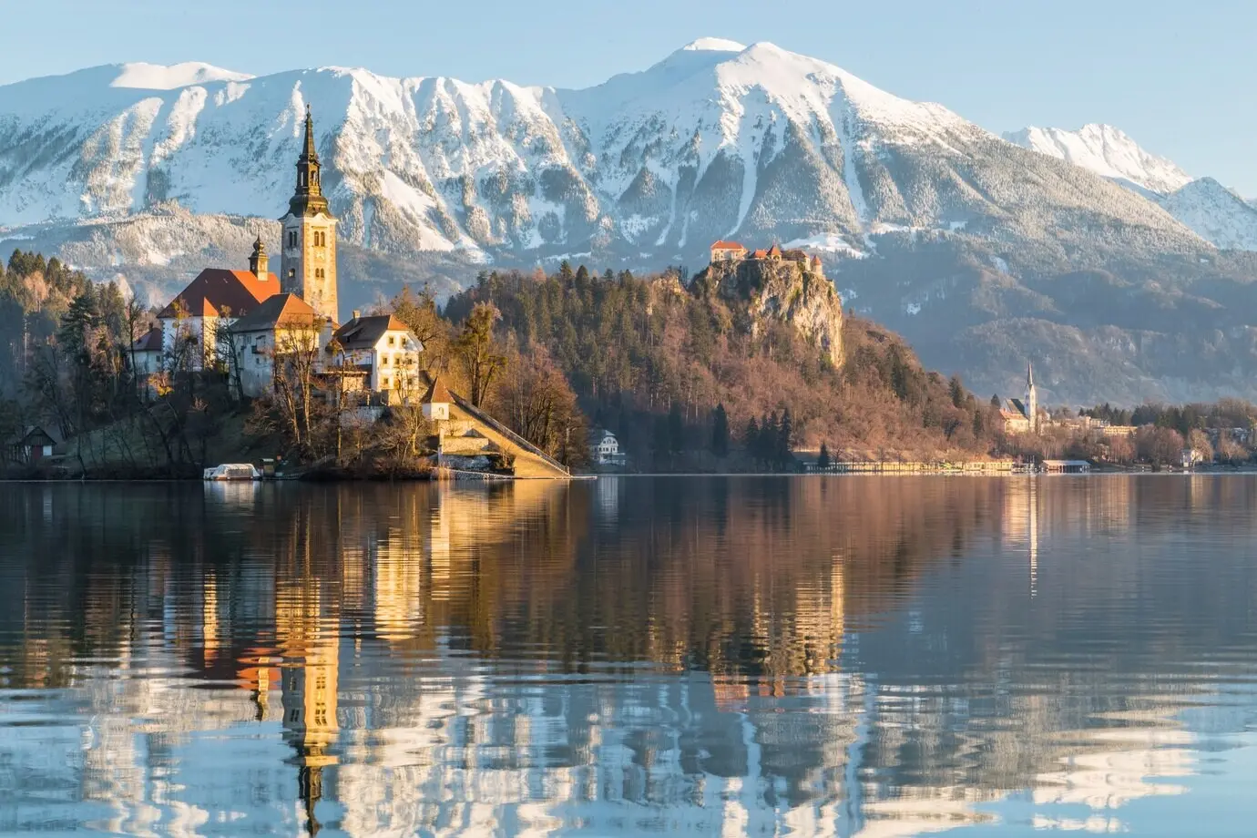Schöne Aufnahme eines Hauses in der Nähe des Sees mit dem Berg Ojstrica in Bled, Slowenien.
